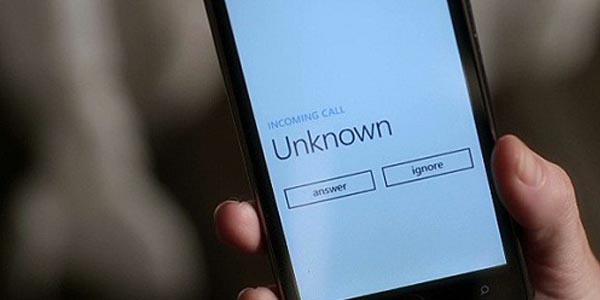 smartphone in hand with incoming call from unknown number